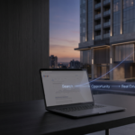 alptop sobre escritorio con edificio moderno al fondo, interfax de Google en la pantalla